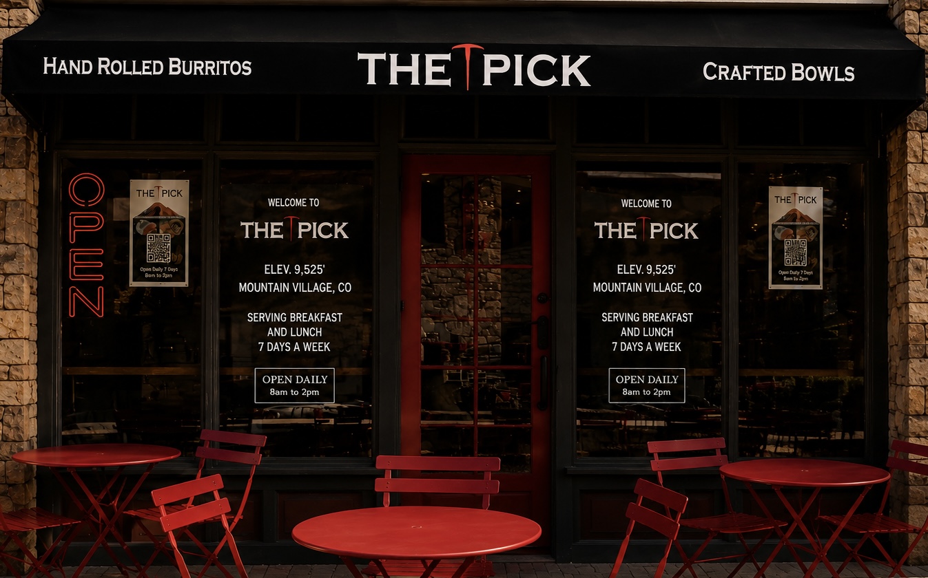 The Pick storefront awning and window signage in Mountain Village, Telluride, with red outdoor bistro tables